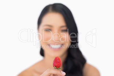 Attractive brown haired model holding strawberry