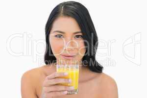 Sensual nude model holding orange juice