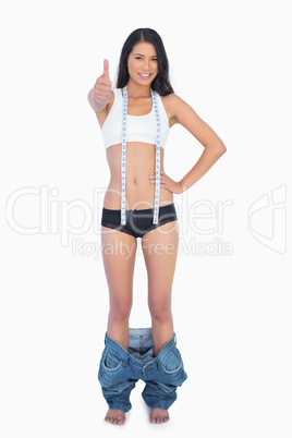 Sexy woman with too big pants on her ankles thumbs up