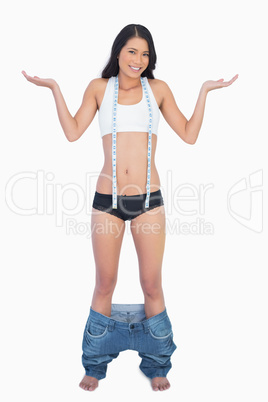 Smiling woman wearing jeans falling down because shes lost weigh