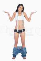 Smiling woman wearing jeans falling down because shes lost weigh