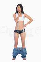 Pensive woman wearing jeans falling down because shes lost weigh