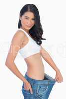 Self confident woman holding her too big jeans