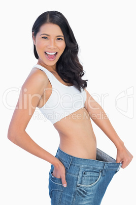 Victorious woman holding her too big pants