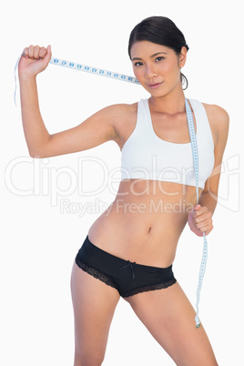 Self confident slim woman holding her measuring tape