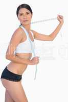 Self confident slim woman playing with her measuring tape