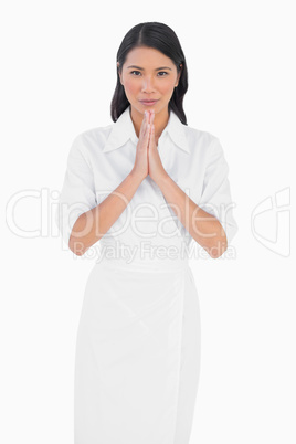 Elegant dark haired model with white dress joining hands