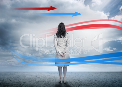 Businesswoman looking at red and blue arrows