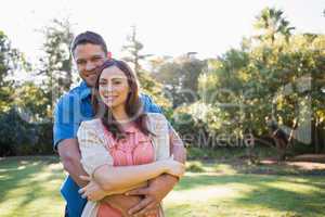 Embracing couple outside on sunny day