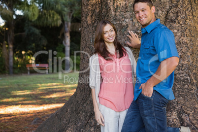 Couple leaning on a tree