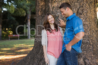 Man and woman leaning on a tree