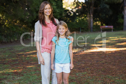 Mother smiling at camera with her daughter