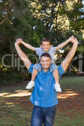 Father giving son piggy back and stretching out their arms