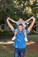 Father giving son piggy back and stretching out their arms