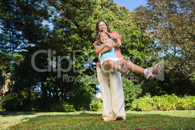 Mother swinging her daughter around having fun