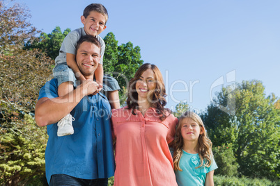Happy family smiling at camera in the park