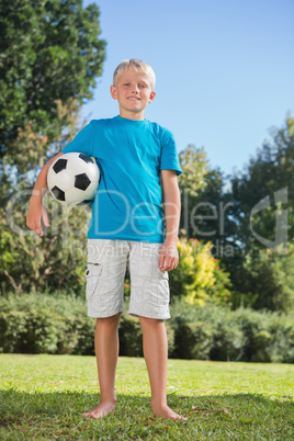 Young blonde boy holding football