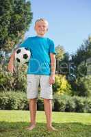 Young blonde boy holding football