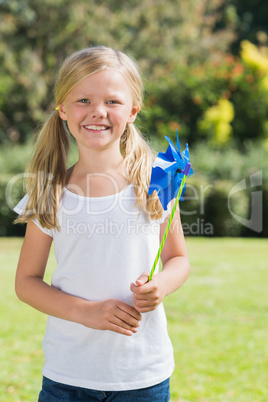 Blonde girl smiling and holding pinwheel