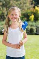 Blonde girl smiling and holding pinwheel