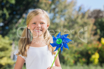 Young blonde girl holding pinwheel smiling at camera