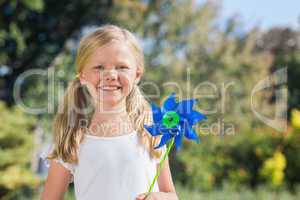 Young blonde girl holding pinwheel smiling at camera