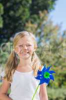 Cute blonde girl holding pinwheel smiling at camera