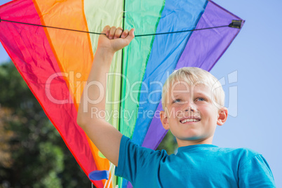 Child raising his arm with a kite in it