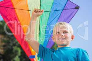Child raising his arm with a kite in it