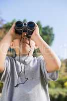 Boy looking through binoculars to the sky