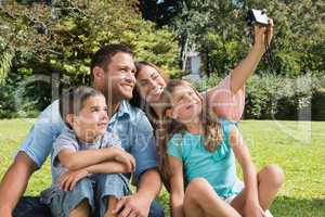 Smiling family in a park taking photos