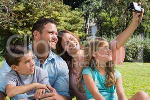Happy family in a park taking photos