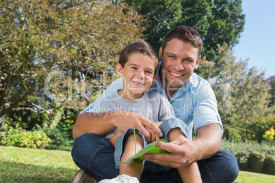 Smiling dad and son holding a leaf
