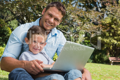 Smiling son and dad with a laptop