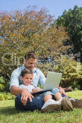 Cheerful dad and son with a laptop