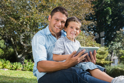 Happy dad and son with a tablet pc