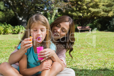 Mother and daughter making bubbles