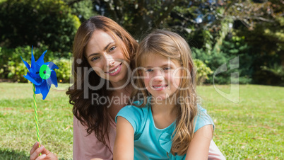 Happy mother and daughter holding pinwheel