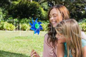 Mother with daughter with a pinwheel in the park