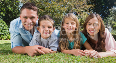 Smiling family lying on the grass Smiling family lying on the grass