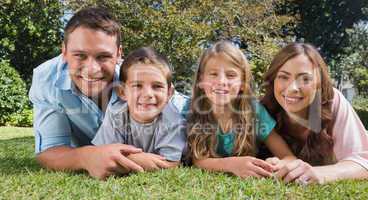 Smiling family lying on the grass