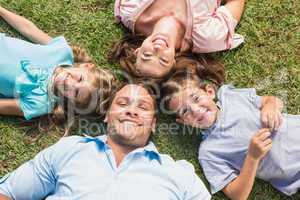 Happy family lying on the grass in a circle