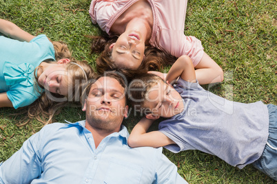 Sleeping family lying on the grass in a circle