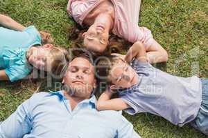 Sleeping family lying on the grass in a circle