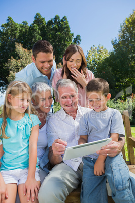 Multi generation family with a tablet pc sitting in park