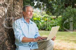 Mature man with a laptop looking into the sky