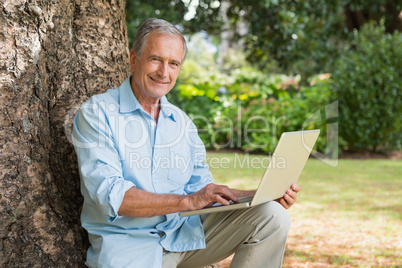 Smiling old man with a laptop