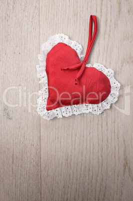Red heart shape on a wooden background with space for text