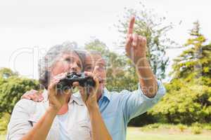 Man showing something to his wife holding binoculars