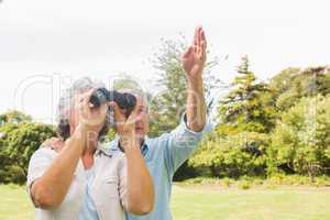 Man pointing to something for his wife holding binoculars